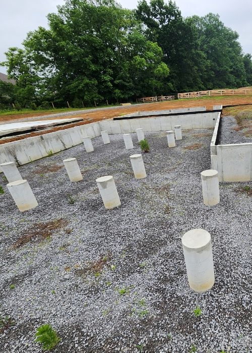 A group of cement poles sitting on top of a gravel field